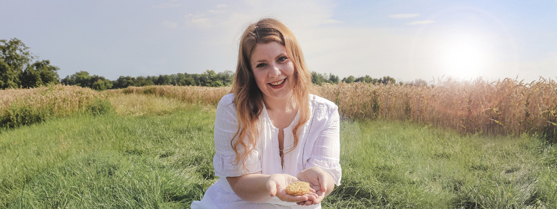 Junge Frau sitzt in einem Feld