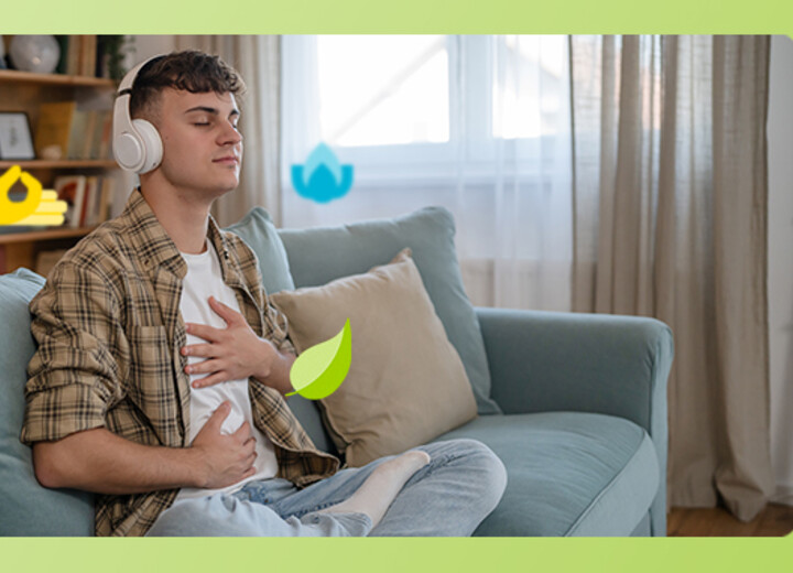 Junger Mann sitzt auf dem Sofa und meditiert