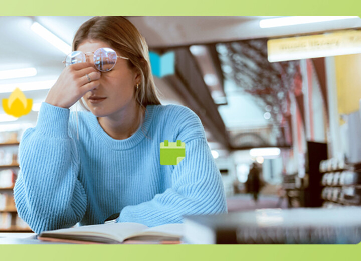 Junge Frau sitzt erschöpft in der Bibliothek