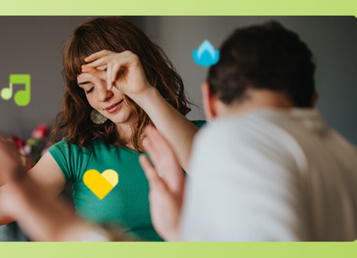 Junge Frau und junger Mann tanzen durch die Wohnung.