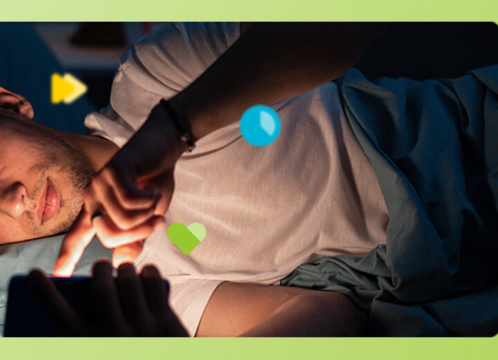 Junger Mann im Bett liegend am Handy