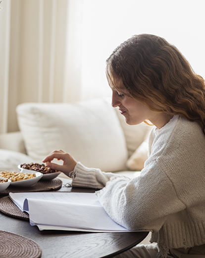 Frau isst Nüsse und liest