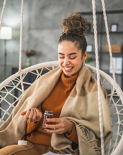Frau in Hängesitz nimmt Supplements
