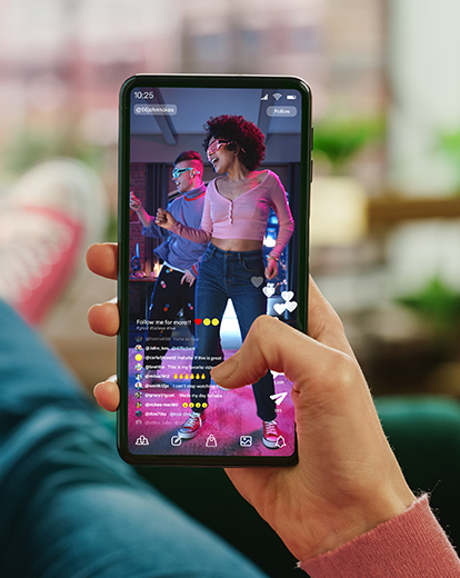 Handy mit geöffneter TikTok App, auf der eine tanzende Frau zu sehen ist