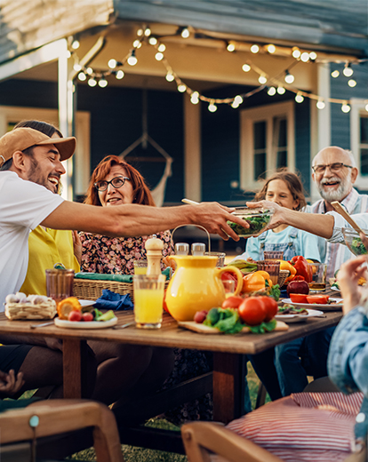 Viele Menschen sitzen um einen Tisch herum und essen gemeinsam