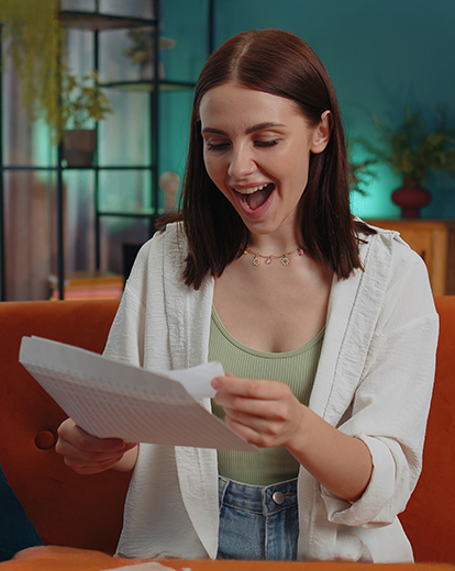 Junge Frau liest glücklich geöffneten Brief