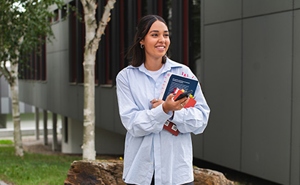 Lachende Frau mit Buch in der Hand